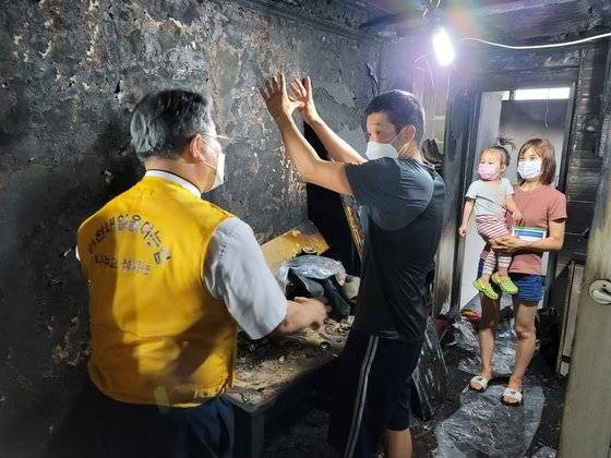 텔뭉(가운데)씨가 이준모 목사(왼쪽)에게 화재 당시 상황을 설명하고 있다. 사진 이준모 목사 제공