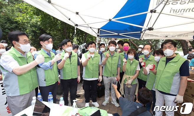 국민의힘 이준석 대표와 서병수 경선준비위원장이 4일 서울 용산구 동자동 쪽방촌에서 대선 경선후보들과 함께 혹서기 취약계층 주민들을 위한 음식 전달 봉사활동에 앞서 파이팅을 외치고 있다. 왼쪽부터 서병수 위원장, 하태경, 황교안, 원희룡 후보, 이준석 대표, 장성민 후보, 최재형 후보의 부인 이소연 씨, 장기표, 윤희숙, 안상수 후보.  © News1 국회사진취재단