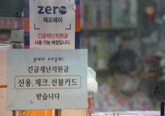 2일 오후 서울 종로구 통인시장 한 가게에 붙은 긴급재난지원금 사용 가능 안내 문구. 연합뉴스