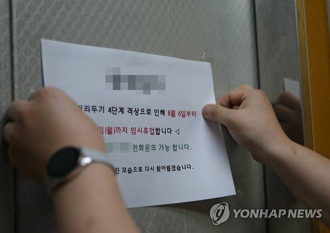 거리두기 4단계에 창원 상점 임시휴업 (창원=연합뉴스) 한지은 기자 = 경남 창원시가 6일부터 사회적 거리두기를 4단계로 격상한 가운데 상남동 한 음식점 직원이 임시휴업을 알리는 안내문을 부착하고 있다. 2021.8.6 contactje@yna.co.kr