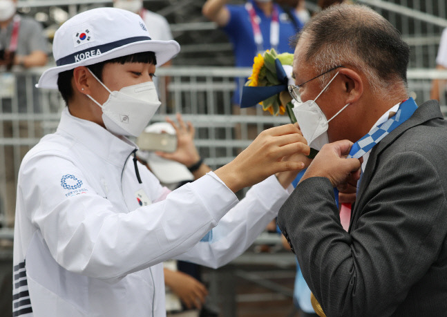 지난달 30일 일본 유메노시마 공원 양궁장에서 열린 도쿄올림픽 양궁 여자 개인전 결승에서 금메달을 차지한 안산이 정의선 현대차그룹 회장의 목에 금메달을 걸어주고 있다. 혼성 단체전, 여자 단체전에서 2개의 금메달을 목에 건 안산은 개인전 결승에서도 승리해 사상 첫 올림픽 양궁 3관왕이 됐다.도쿄 | 연합뉴스