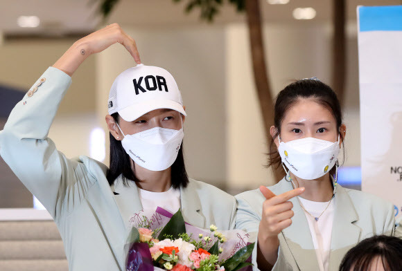 서로 다른 하트의 김연경?김수지 - 9일 오후 인천국제공항 제2터미널 입국장에서 열린 2020 도쿄올림픽 대한민국 선수단 환영식에서 김연경(왼쪽)과 김수지가 팬들을 향해 하트를 보이며 기념촬영을 하고 있다. 2021.8.9 연합뉴스