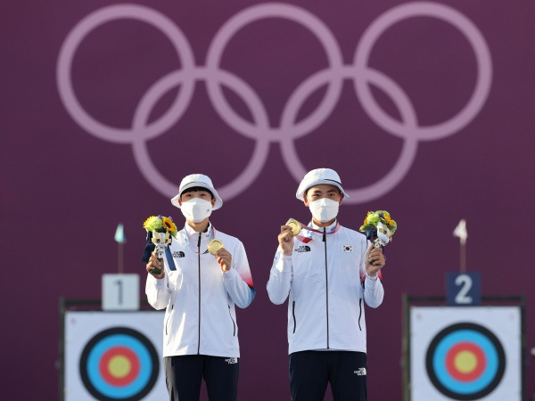 대한민국 양궁대표팀 안산과 김제덕이 2020 도쿄올림픽 혼성단체 결승전에서 금메달을 목에 걸고 포즈를 취하고 있다.(사진=저작권자(c) 뉴스1, 무단 전재-재배포 금지)