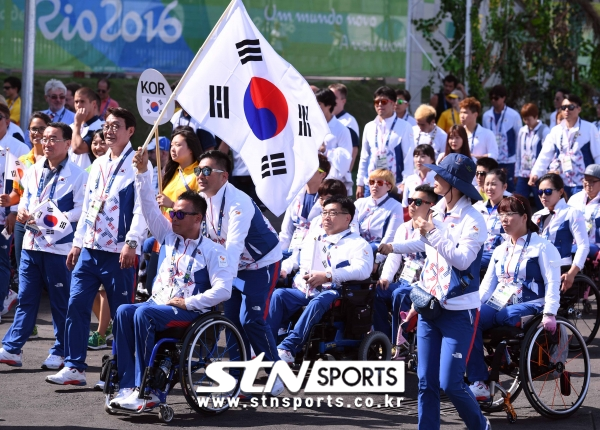 브라질 리우데자네이루 선수촌 플라자에서 '2016 리우 패럴림픽' 한국선수단 입촌식에서 기수인 이하걸 선수가 태극기를 휘날리며 입장하고 있는 모습. 사진｜뉴시스