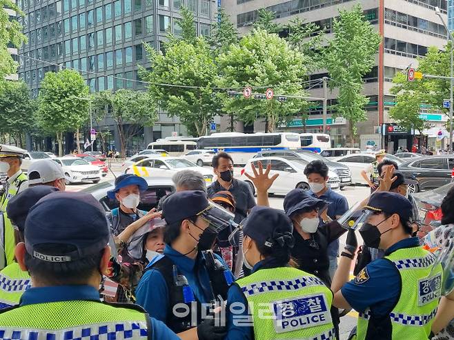 14일 오후 서울 종로구 광화문역 부근에서 ‘1인 걷기 운동’ 참가자들이 구호를 외치며 소리를 지르자 경찰이 에워싸고 있다.(사진=조민정 기자)