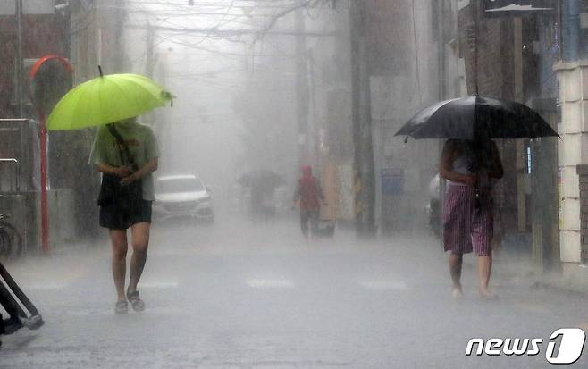 소나기가 내리는 19일 오후 서울 마포구 망원시장 앞 골목에서 우산을 쓴 시민들이 발걸음을 재촉하고 있다. 2021.7.19/뉴스1 © News1 박세연 기자