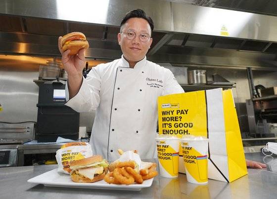 신세계푸드 R&D센터에서 이재호 노브랜드버거 메뉴개발 파트장이 직접 개발한 페퍼로니 버거와 어니언 도넛 등 메뉴를 선보이고 있다. [사진 신세계푸드]