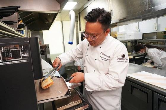 페퍼로니 차아바타 샌드위치를 오븐으로 구우며 온도와 맛을 체크 중인 이재호 파트장. [사진 신세계푸드]