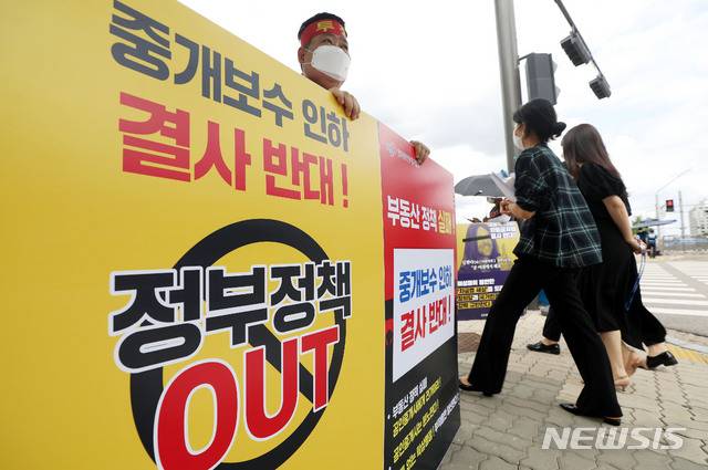[서울=뉴시스] 홍효식 기자 = 부동산 중개보수를 정부가 개편하는 방안을 추진하고 있는 17일 오후 서울 영등포구 국회 앞에서 한국공인중개사협회 회원이 중개보수 인하 결사 반대를 촉구하며 1인 시위를 하고 있다. 2021.08.17. yesphoto@newsis.com