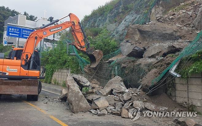 집중 호우에 떨어진 돌무더기 긴급 제거 (강릉=연합뉴스) 이해용 기자 = 호우 경보가 내려지면서 게릴라성 집중호우가 쏟아진 18일 오전 강원 강릉 시내에서 도로에 떨어진 돌무더기를 치우는 작업이 한창 진행되고 있다. 2021.8.18 dmz@yna.co.kr