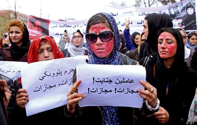2015년 3월 24일 아프가니스탄 수도 카불에서 여성 시위자들이 얼굴에 붉은색 페인트를 칠한 채 가두행진을 하고 있다. 붉은색 페인트는 피투성이가 된 파르쿤다의 얼굴을 상징한다. 카불=AFP 연합뉴스