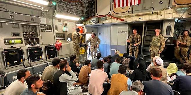 미국 중부사령부 사령관인 프랭크 맥켄지 해병대 장군이 지난 17일(현지시간) 카불의 하미드 카르자이 공항을 떠나는 수송기에 미국을 도왔던 아프간인들이 몸을 싣자 둘러보기 위해 들어서고 있다.미 해군 제공 AP 연합뉴스