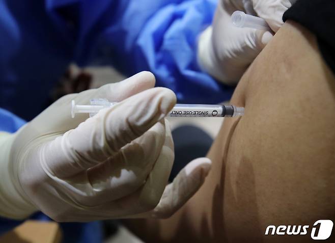 20일 서울 종로구 코로나19 예방접종센터에서 의료진이 시민에게 백신을 접종하고 있다. © News1 김진환 기자