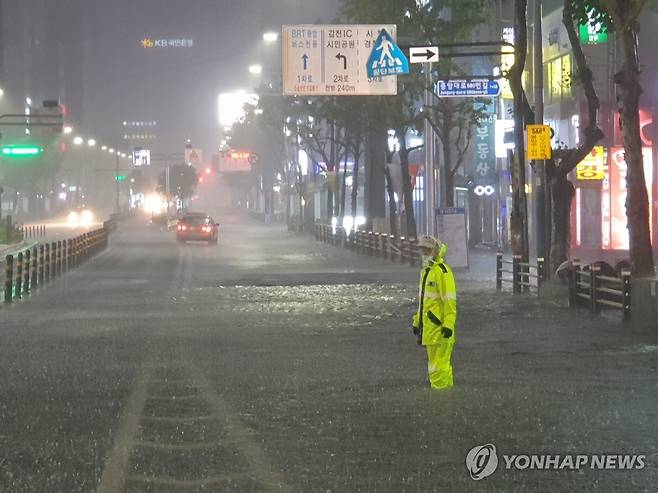 침수된 도로 교통정리 하는 경찰 (부산=연합뉴스) 손형주 기자 = 태풍 오마이스가 경남 고성에 상륙한 24일 밤 부산 서면 삼정 타워 앞 도로가 침수돼 경찰이 교통정리를 하고 있다. 2021.8.24 [부산경찰청 제공. 재판매 및 DB 금지] handbrother@yna.co.kr
