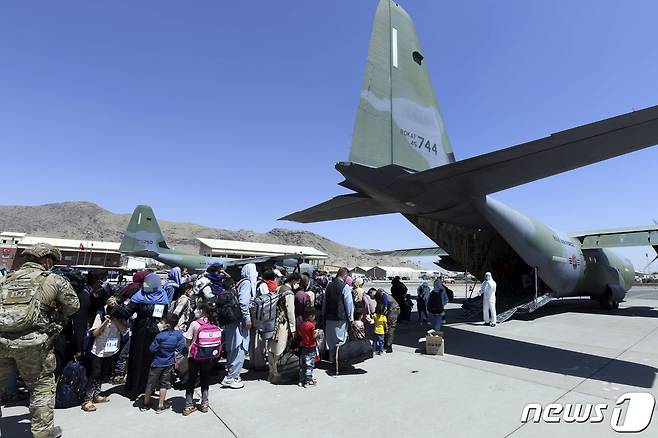 국내 이송이 결정된 아프가니스탄인과 가족들이 25일(현지시간) 카불공항에서 우리 공군 수송기 C-130J '슈퍼 허큘리스'에 탑승하기 위해 대기하고 있다. (공군 제공) 2021.8.26/뉴스1