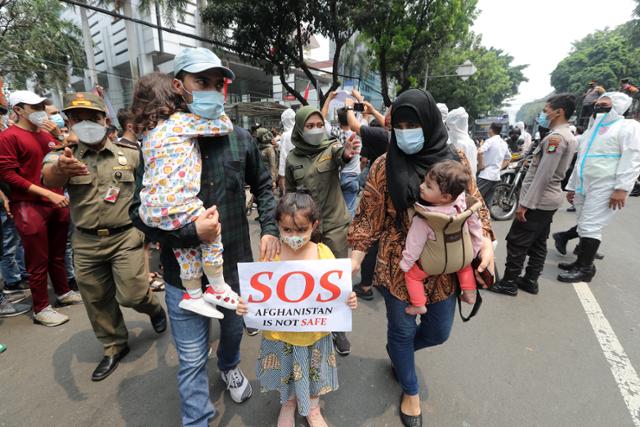 인도네시아 내 아프가니스탄 출신 주민들이 24일 자카르타의 유엔난민기구 대표부 앞에서 아프간 난민의 제3국 정착 지원을 요청하는 시위를 하고 있다. 자카르타=EPA 연합뉴스