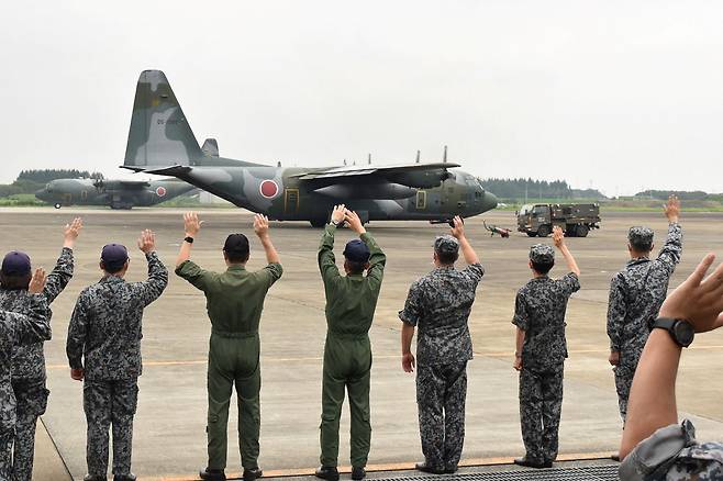 日本航空自衛隊輸送機 C-130が自国民と現地人助力者待避任務のために 24日埼玉県でアプガニスタンに急派されると離陸の前現地部隊員たちが歓送している. しかし, この輸送機はアフガン現地人を一人も待避させることができなかった. [AFP]