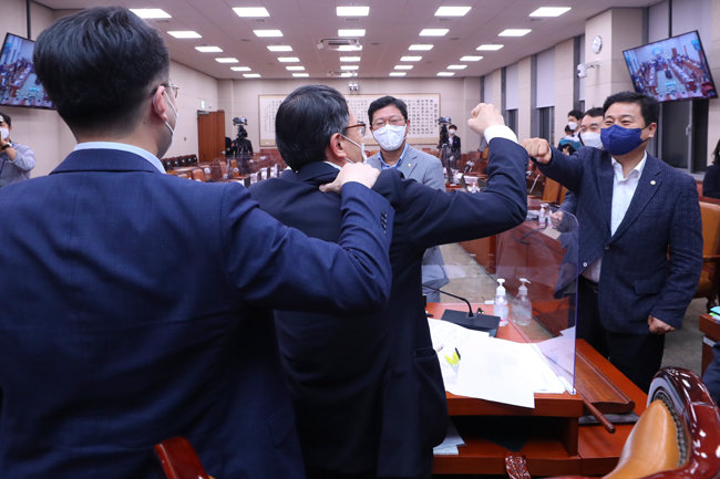 8월 25일 오전 3시 54분, 더불어민주당과 열린민주당은 국민의힘이 불참한 가운데 국회 법제사법위원회에서 언론중재법 개정안을 처리했다. 처리 직후 여당 의원들은 웃으며 자축했다. 오른쪽부터 민주당 김영배 김용민 김승원 의원. 김남국 의원(왼쪽)은 김영배 의원과 주먹 인사를 나누는 박주민 의원(왼쪽 두 번째)의 어깨를 주무르고 있다. [원대연 동아일보 기자]