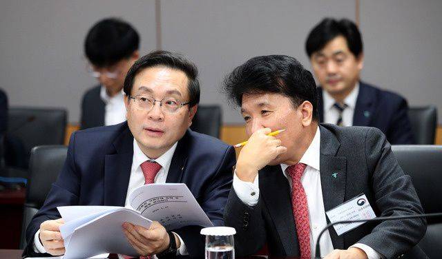 손태승 당시 우리은행장(왼쪽)과 함영주 당시 하나은행장이 2019년 1월 서울 종로구 정부서울청사에서 열린 가계부채관리 점검회의에서 대화하는 모습. /뉴시스