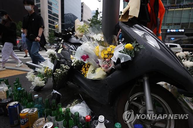 배달 라이더 사망사고 추모 지난 27일 오후 서울 강남구 선릉역 인근 도로에 전날 사망한 오토바이 배달원을 추모하는 국화꽃 등이 놓여 있는 모습. [연합뉴스 자료사진]