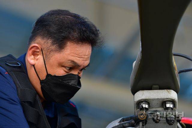 한 정비사가 헬기의 회전 날개를 분리하며 구슬땀을 흘리고 있다.