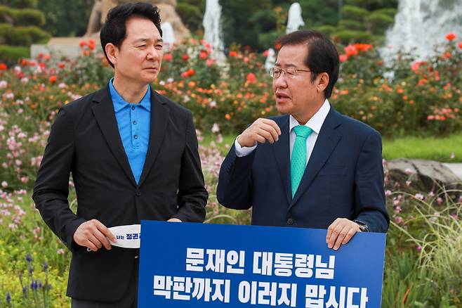 지난달 29일 청와대 앞에서 1인 시위를 벌이고 있는 국민의힘 대선주자인 홍준표 의원앞에 장성민 후보가 찾아와 대화하고 있다. 뉴스1