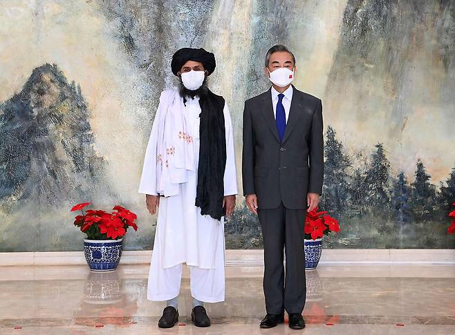 7월28일 왕이 중국 외교부장(오른쪽)이 톈진에서 탈레반 2인자 물라 압둘 가니 바라다르와 만났다. ⓒAFP PHOTO