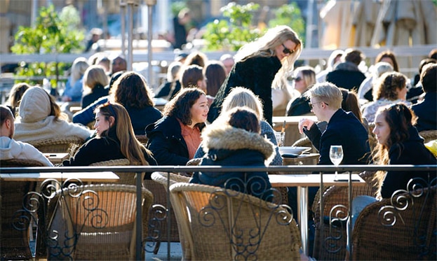 코로나 사태 확산이 한창이던 지난 3월, 스웨덴 수도 스톡홀름의 한 노천카페에 사람들이 모여있다.