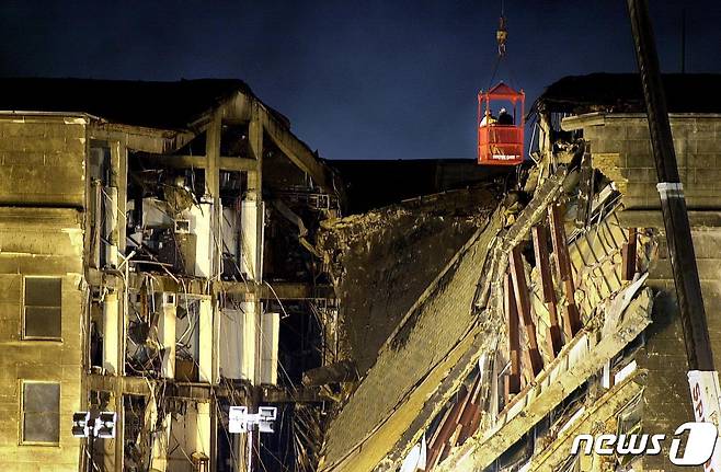 구조대원 2명이 크레인을 타고 펜타곤 건물의 충돌 현장을 조사하고 있다. 2001.09.12 © AFP=뉴스1