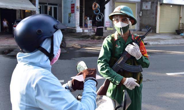 지난달 23일 베트남 호찌민시에 배치된 군인이 이동을 시도하는 시민의 통행증을 검사하고 있다. VN익스프레스 캡처