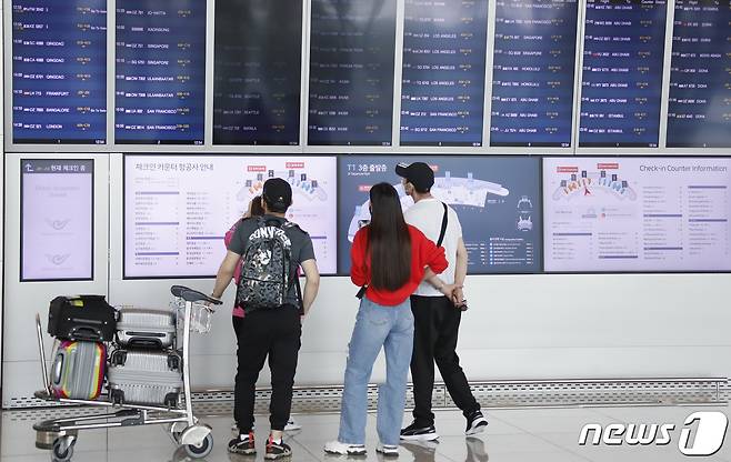 여행객들이 11일 오후 인천국제공항 제1터미널에서 출국하기 전 항공편 정보를 보고 있다. 정부는 코로나19 백신 접종 완료자에 한해 이르면 7월부터 싱가포르와 괌, 사이판 등 단체 해외여행을 허용하는 여행안전권역(트래블 버블)을 추진한다고 밝혔다. 2021.6.11/뉴스1 © News1 권현진 기자