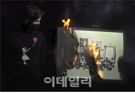 ‘불탄 뱅크시’는 2021년 3월 11일 크리스티의 비플 경매 직전 자신들이 구매한 1억 700만 원의 뱅크시의 판화 작품인 ‘멍청이’를 스캔해 NFT로 만든 뒤 불에 태우는 이벤트를 트위터로 공개했다. 유튜브에는 2021년 3월 4일 영상이 올라온 터였다. (사진=유튜브)