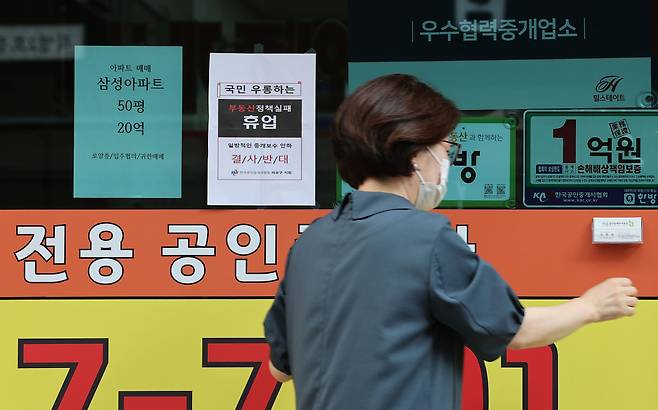 정부가 부동산 중개 수수료 개편을 마련 중인 가운데 19일 오후 서울 시내의 한 부동산중개업소에서 관계자가 중개수수료 인하 정책에 반대하는 휴업 안내문을 붙이고 있다./연합뉴스 제공