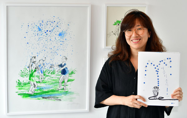 이수지 작가가 지난 5일 서울 한남동 알부스갤러리에서 새로 출간한 그림책 ‘여름이 온다’를 들어 보이고 있다. 이곳에선 ‘여름이 온다’에 사용된 원화 등 이수지 그림들을 전시 중이다. 최현규 기자