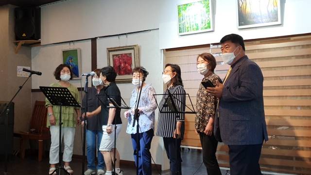 11일 인천공항 인근 공항신도시 영종프라자 5층 우동꽃 갤러리카페에서 진행된 비대면 오아시스음악회에서 장애자녀를 예술가로 키운 부모들이 '길가에 앉아서'를 부르며 모처럼의 무대를 만끽하고 있다. (사)꿈꾸는마을 제공