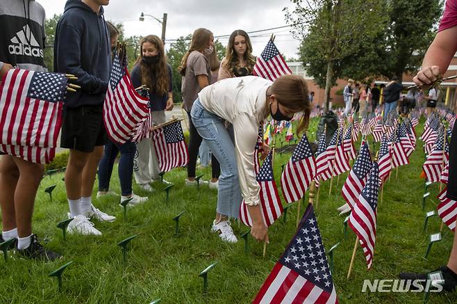 [조지아=AP/뉴시스] 9일(현지시간) 미국 조지아주에 위치한 시더 그로브 고등학교에서 학생들이 9·11 테러 희생자를 추모하며 깃발을 설치하고 있다. 2021.09.10.