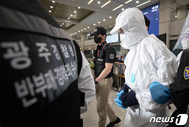 광주 학동 붕괴 참사와 관련해 금품수수 의혹을 받고 해외로 도피한 문흥식 전 5・18구속부상자회장이 11일 오후 인천국제공항으로 자진 귀국한 후 경찰에 압송되고 있다. 2021.9.11/뉴스1 © News1 이재명 기자