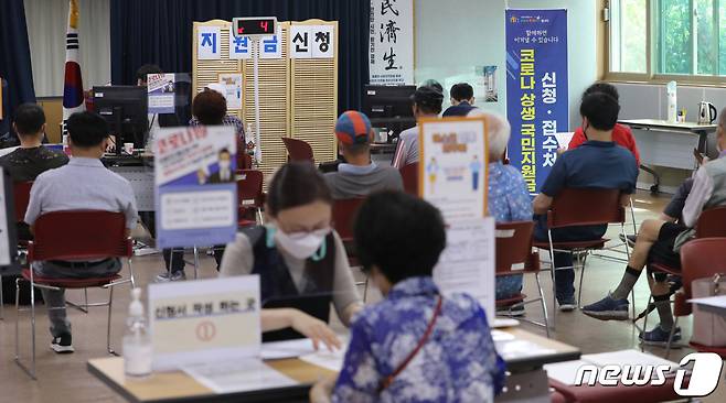 코로나 상생 국민지원금 오프라인 신청 첫날인 13일 경기도 수원시 팔달구 행궁동행정복지센터에서 시민들이 현장 신청을 하고 있다. 신청 첫 주에는 요일제 원칙에 따라 주민등록상 출생연도 끝자리 순서대로 신청이 가능하며 13일은 주민등록상 출생연도 끝자리가 1·6인 사람이 신청할 수 있다. 화요일은 2·7, 수요일은 3·8, 목요일은 4·9, 금요일은 5·0인 사람이 신청하면 된다. 2021.9.13/뉴스1 © News1 김영운 기자