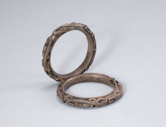 무령왕릉비가 살아있을때부터 찼을 것으로 추정되는 은팔찌. 팔찌 안쪽에 만든 사람과 일자가 새겨져있다. 사진 국립공주박물관