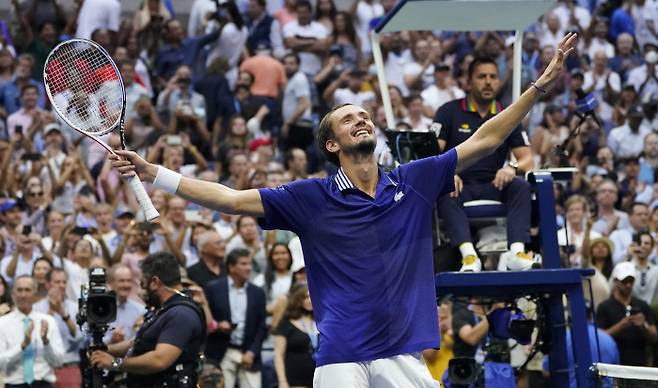 다닐 메드베데프가 13일 미국 뉴욕의 빌리진 킹 내셔널 테니스센터에서 끝난 US오픈 남자 단식 결승에서 첫 메이저대회 정상에 오른 뒤 두 팔을 벌리며 기뻐하고 있다. 결승전 상대 노바크 조코비치(아래)는 메드베데프에게 박수를 치며 캘린더 그랜드슬램 무산의 아쉬움을 달랬다.   뉴욕 | AP연합뉴스