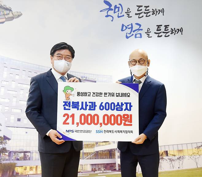 김용진 국민연금공단 이사장(왼쪽)이 이병관 전북사회복지협의회장(오른쪽)과 함께 14일 ‘제수용 과일 나눔’ 전달식에서 기념 촬영을 하고 있다. /국민연금공단 제공