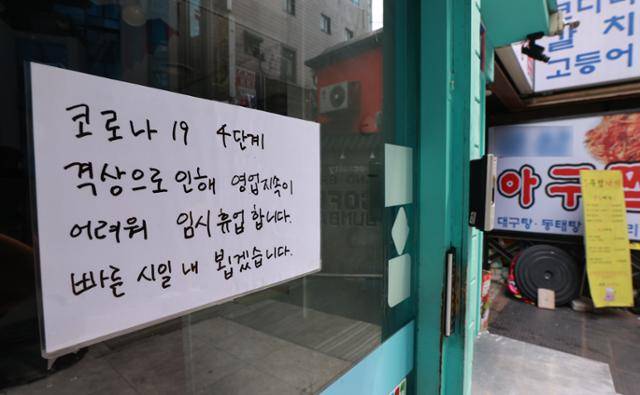 5일 서울 종로구의 한 식당 출입문에 신종 코로나바이러스 감염증(코로나19) 사회적 거리두기 4단계로 인한 일시 영업 중단 안내문이 부착돼 있다. 연합뉴스
