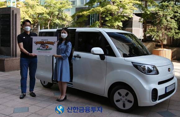 정재윤 신한금융투자 디지털마케팅셀장(사진 왼쪽)이 서울 여의도 본사 앞에서 '소원성취 이벤트' 당첨자인 권민지 고객에게 도심형 캠핑카를 증정했다. [사진=신한금융투자]