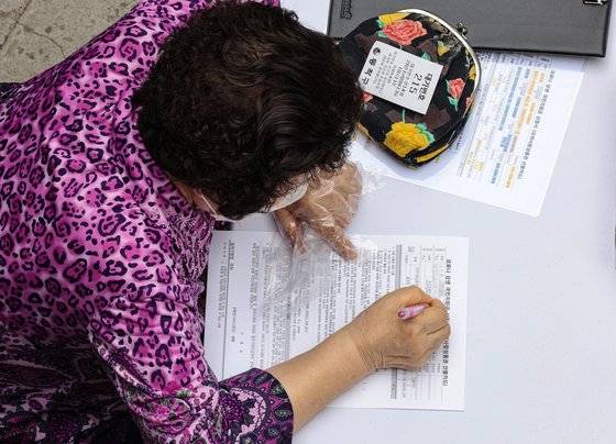 신종 코로나바이러스 감염증(코로나19) 상생 국민지원금 대면 신청 첫날인 13일 오전 서울 동작구 대방동 주민센터를 찾은 어르신이 신청서 작성을 하고 있다. 연합뉴스