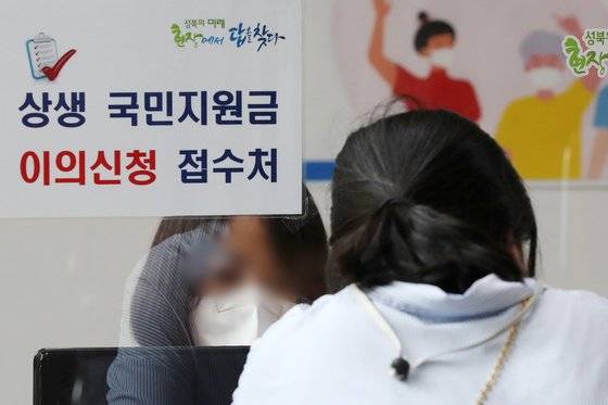 서울 성북구 길음1동 주민센터에 마련된 코로나 상생 국민지원금 상담 창구에서 한 시민이 이의신청 접수를 하고 있다. 홍남기 경제부총리는 지난 8일 코로나 상생 국민지원금 지급에 따른 국민의 이의신청이 폭주하고 있다는 지적에 대해