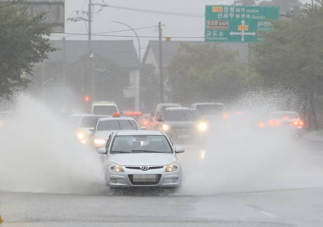 태풍 찬투의 영향으로 제주도 육상 전역에 호우특보가 내려진 14일 오전 제주시 한북로의 도로가 물에 잠겨 차량이 서행하고 있다. [연합]