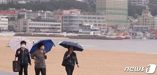 부산 해운대구 해수욕장을 찾은 시민들이 우산을 쓰고 백사장을 걷고 있다. 2020.6.18/뉴스1 © News1 여주연 기자