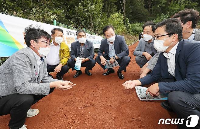 우석대 진천캠퍼스 강석표 교수(왼쪽)팀이 사용기술 개발에 성공한 고감성 흙을 산책로에 시공한 뒤 참석자들에게 설명하고 있다.(우석대 제공)© 뉴스1