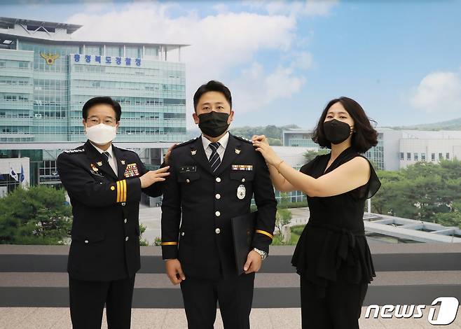 수십억원대 중고차 판매 사기 행각을 벌여 피해자 81명을 낸 중고차 판매조직을 일망타진한 충북경찰청 강력범죄수사대 소속 정주원 경사(가운데)가 계급장을 바꿔달고 있다.(충북경찰청 제공).2021.9.15/© 뉴스1