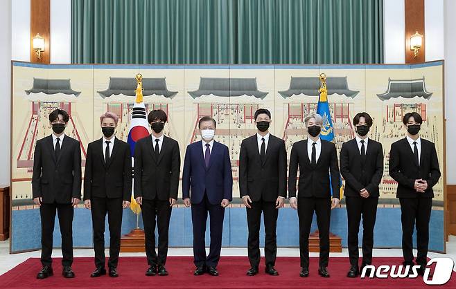 문재인 대통령이 14일 청와대에서 열린 미래세대와 문화를 위한 대통령 특별사절 임명장 수여식에서 아이돌 그룹 방탄소년단(BTS)에게 임명장을 수여하고 기념촬영을 하고 있다. 왼쪽부터 뷔, 제이홉, 진, 문 대통령, RM, 슈가, 지민, 정국. 2021.914/뉴스1 © News1 유승관 기자